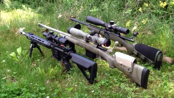 An AR-15 and two bolt action rifles