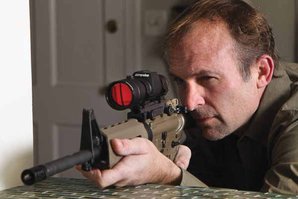 Man with rifle in home