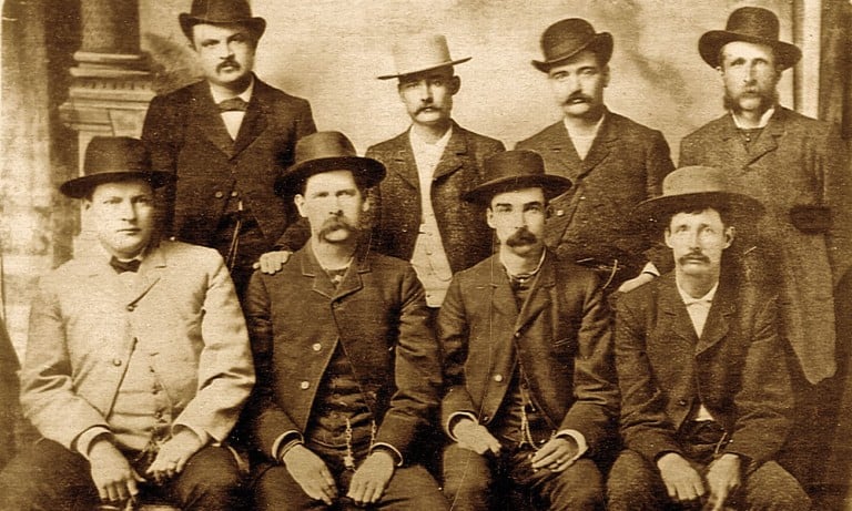 Bat Masterson (standing second from right), Wyatt Earp (sitting second from left), and other deputy marshals during the Wild West era