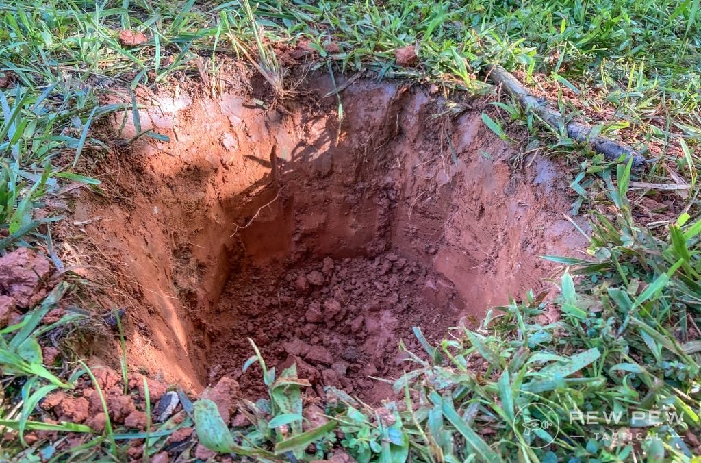 A hole in the ground, about a foot deep and a foot in diameter