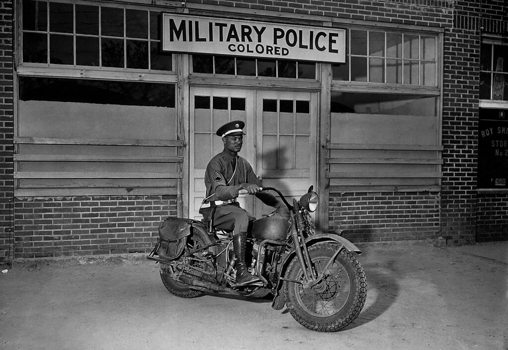 An African American MP in front of segregated military facilities