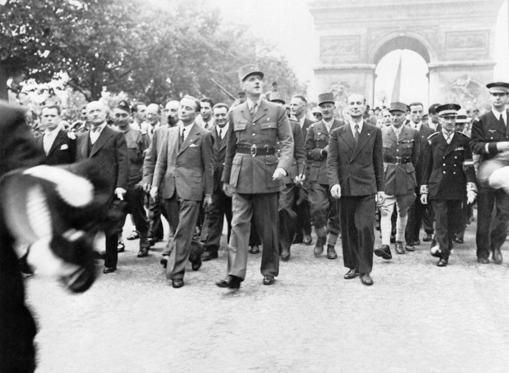 Charles De Gaulle and his entourage walk the streets of a free Paris